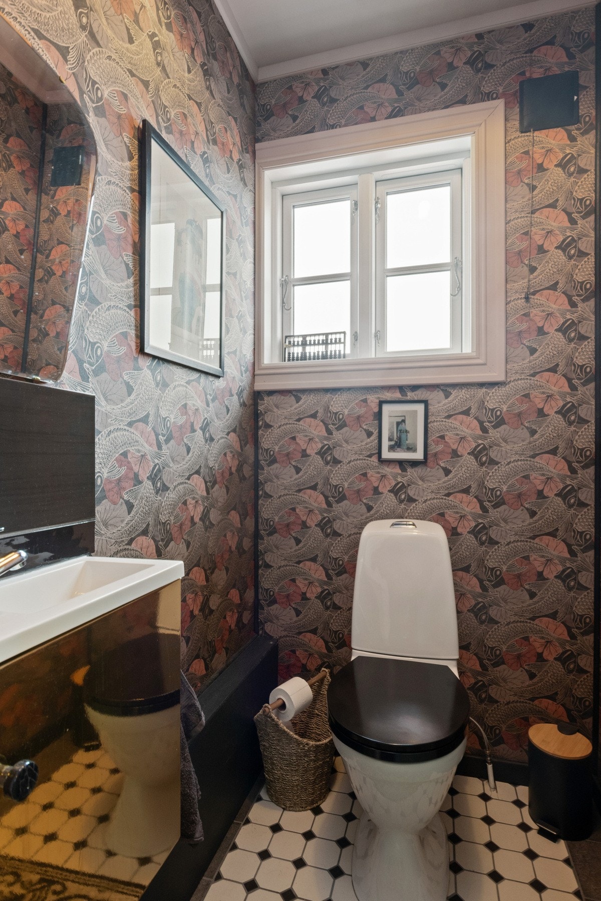 Pent, separat wc-rom med tapetserte vegger og flislagt gulv. Rommet er utstyrt med gulvmontert toalett, moderne servantseksjon og speil. Galleribilde