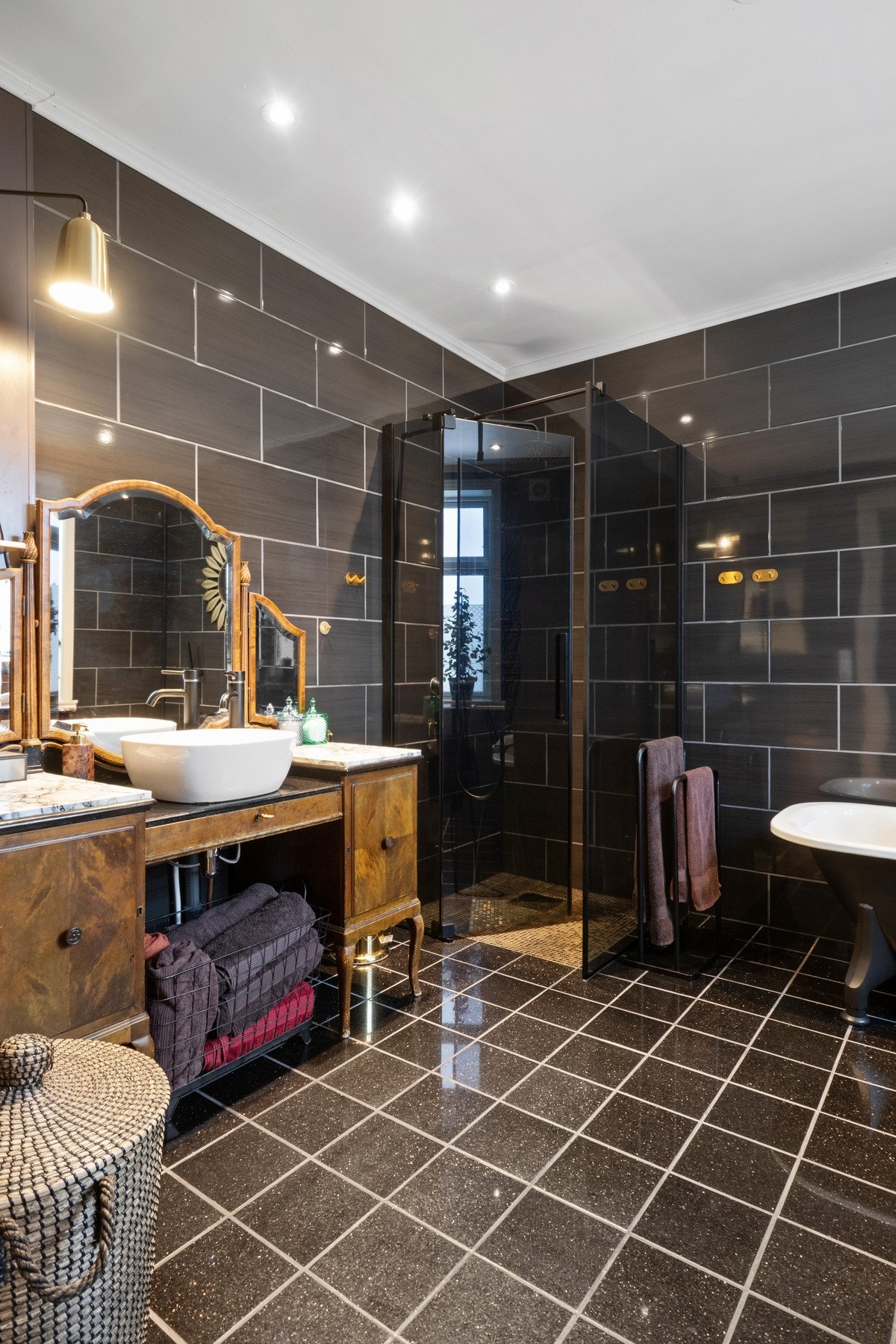 Det er downlights i himlingen, sorte fliser på veggene og matchende fliser på gulv med gulvvarme. Galleribilde