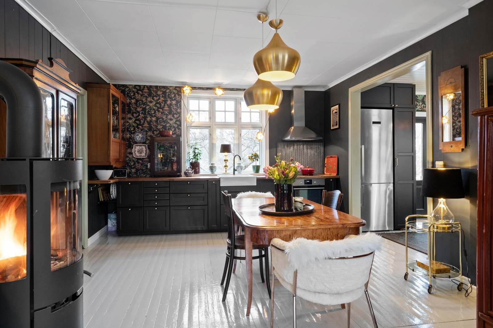 Innredningen har sorte, profilerte fronter, benkeplate og stor oppvaskkum i hvitt porselen, som gir kjøkkenet et stilrent og klassisk preg. Galleribilde