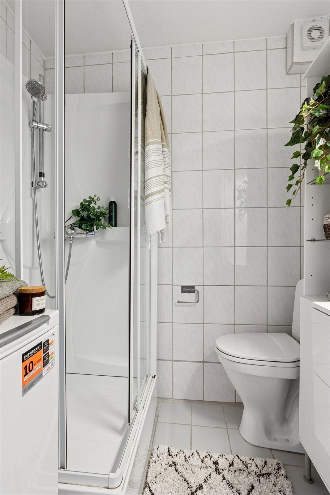 Badet er utstyrt med gulvstående wc, dusjkabinett og innredning med nedfelt servant og skuffer. Avrekk med elektrisk vifte Galleribilde