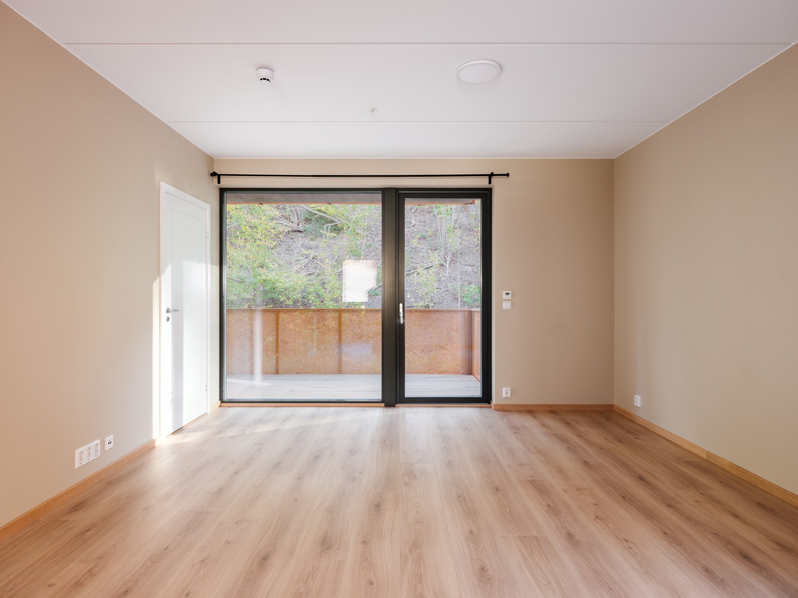 Store vindusflater slipper inn rikelig med lys. Utgang til solrik balkong fra stuen Galleribilde