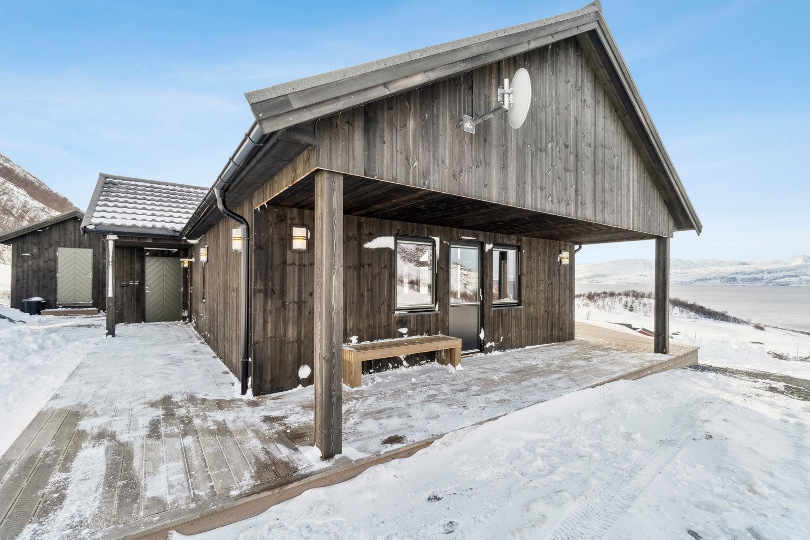 Inn til eiendommen møter du fritidsboligens flotte fasade og uteområder, som inkluderer en stor og flott terrasse som strekker seg rundt store deler av bebyggelsen. Galleribilde