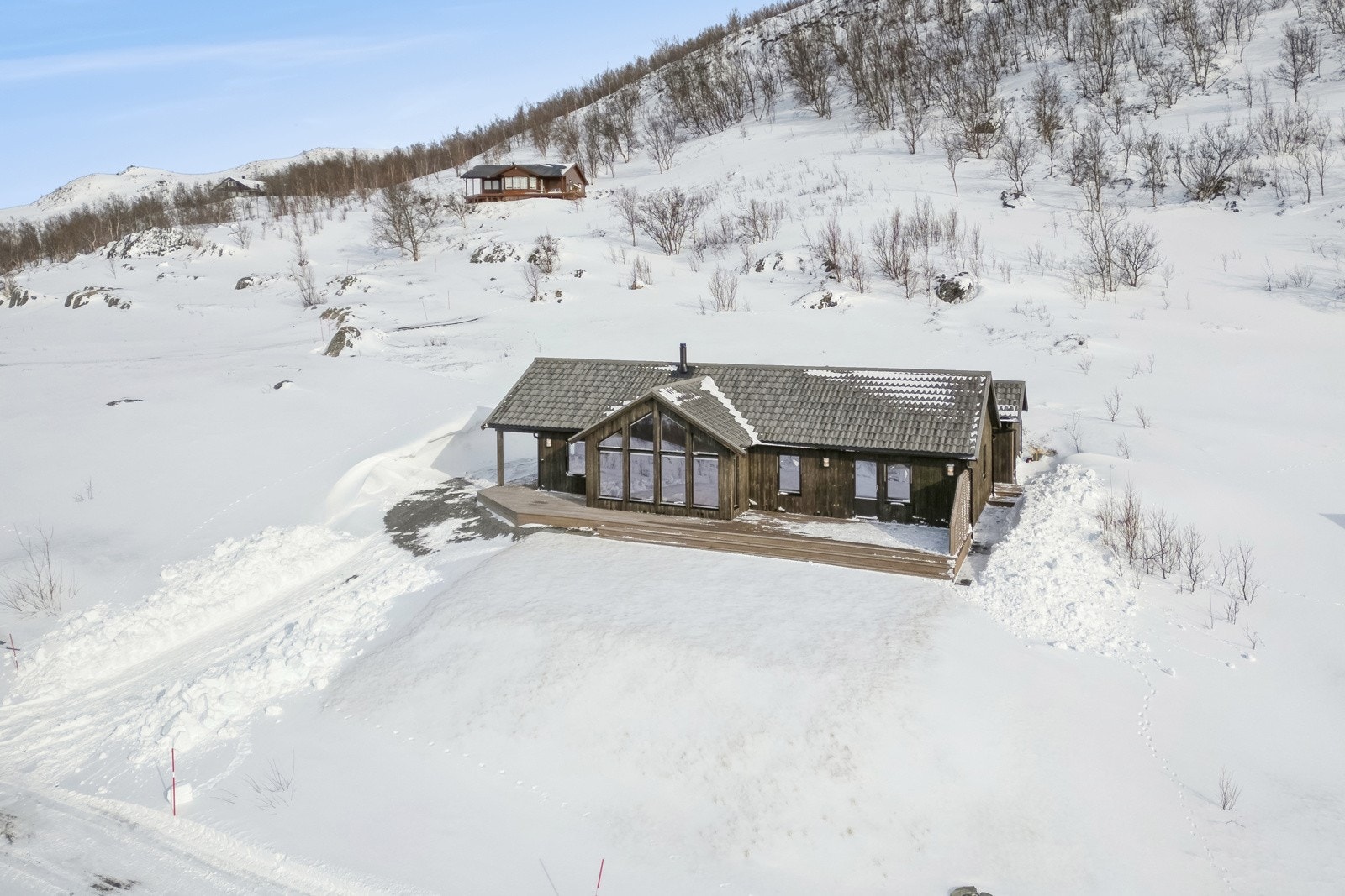 Eiendommen ligger nær slutten av en blindvei, og før avkjørselen til denne finner du en felles parkeringsplass for fritidsboligene i området. Galleribilde