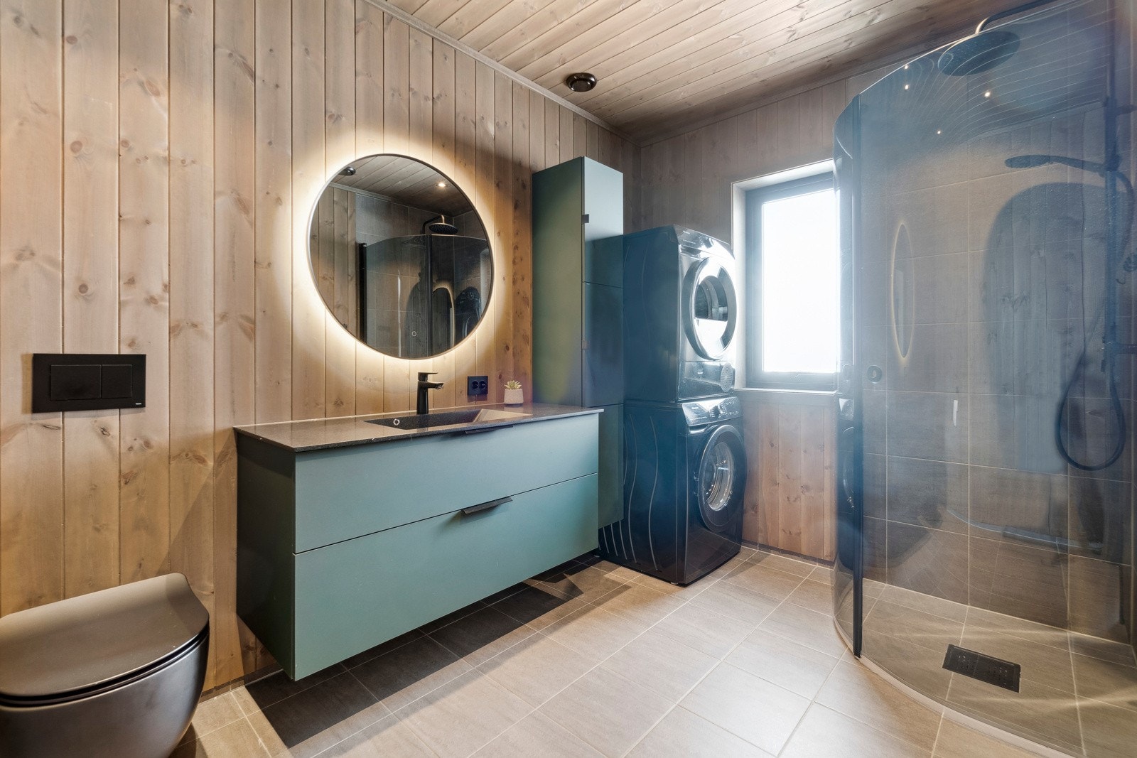 Badet har en praktisk plassering ved soverommene, og fremstår stilfult og pent. Baderomsinnredningen har en lik utførelse som kjøkkenet, noe som gir et gjennomført og helhetlig pent inntrykk. Galleribilde