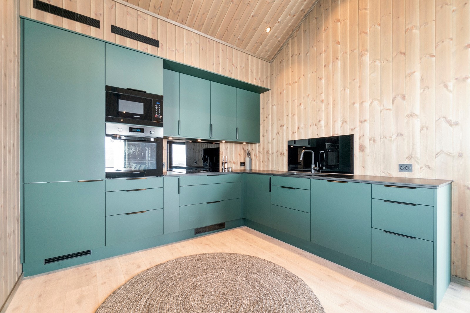 Kjøkkeninnredningen strekker seg over 2 vegger og er innredet i et eget hjørne av planløsningen, og gir deg god oppbevaringsplass i skuffer og overskap. Innredningen er fra AUBO, og kjøkkenet har en koketopp fra BORA med integrert ventilator. Galleribilde