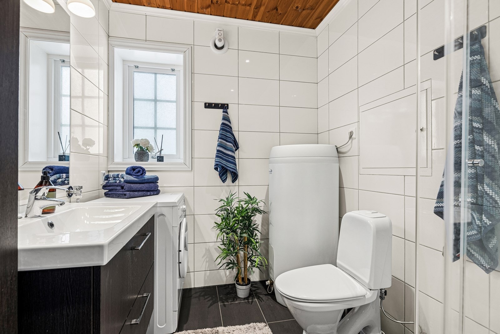 Badet er innredet med heldekkende servant med skuffeseksjon, toalett og dusjkabinett.
Det er også opplegg for vaskemaskin. Galleribilde