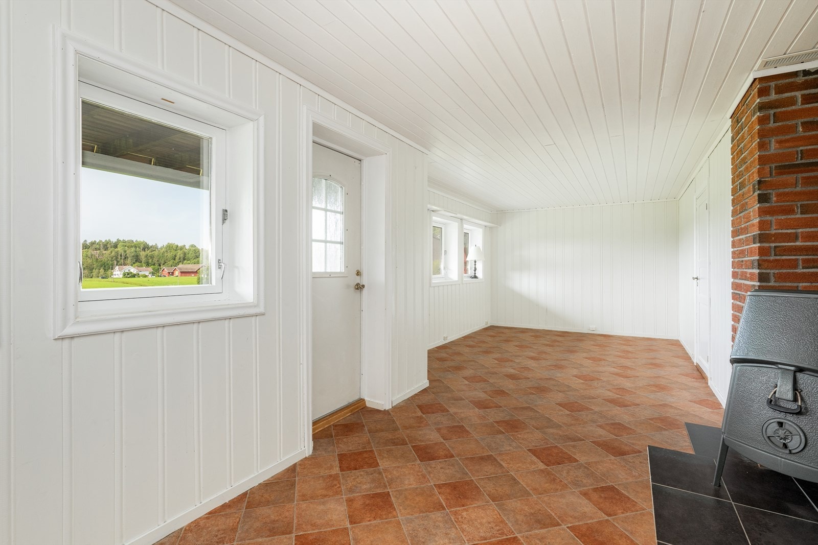 Kjellerstue med peisovn og utgangsdør. Galleribilde