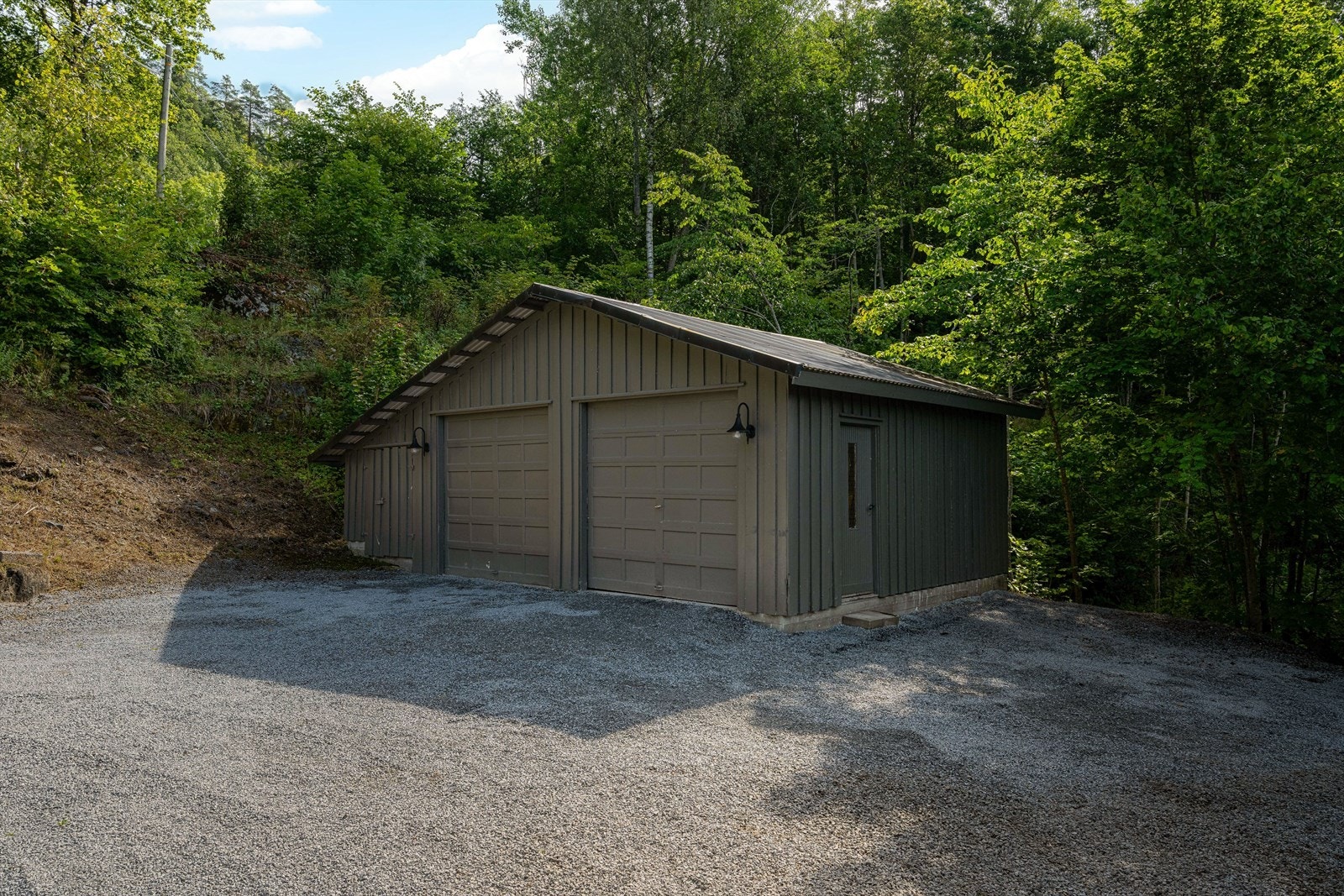 I tillegg til eneboligen er det oppført en dobbelgarasje på eiendommen. Garasjen er 48 kvm stor og oppført i 1985. Det er støpt gulv og to vippeporter. Galleribilde