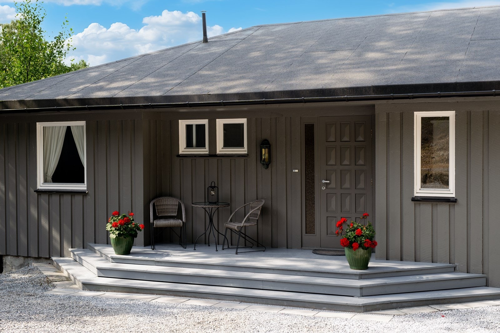 Boligen har et pent og delvis overbygget inngangsparti med en tillaget uteplass og trapp ned til gruslagt gårdsplass. Galleribilde