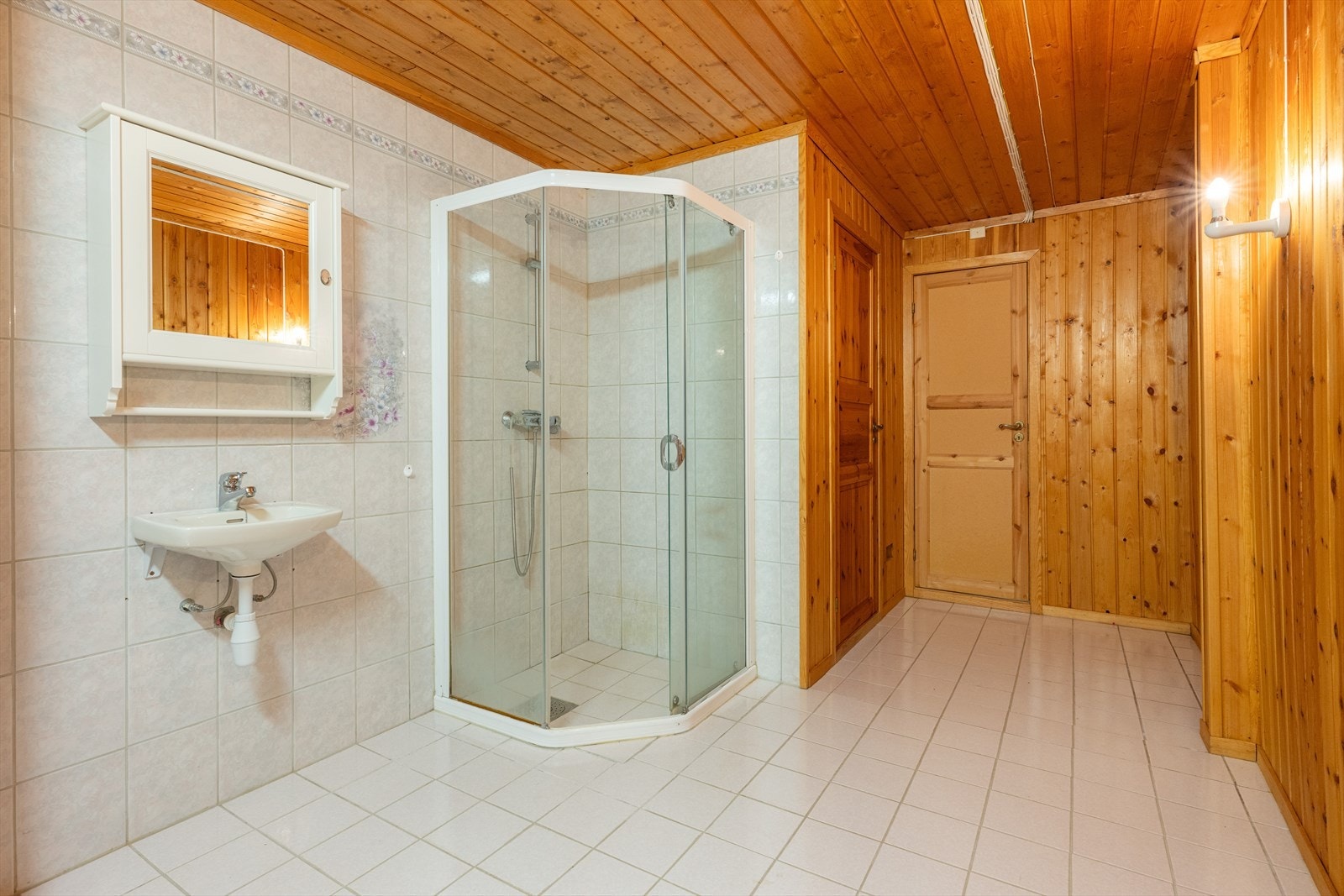 Badet i underetasjen er etter eiers opplysninger etablert i cirka 1995. Gulvet er av flis med varmekabler, vegger er av panel med fliser i våtsone. Himling er av panel. Det er innredning med dusj på vegg med glassvegg og glassdør og servant. Galleribilde