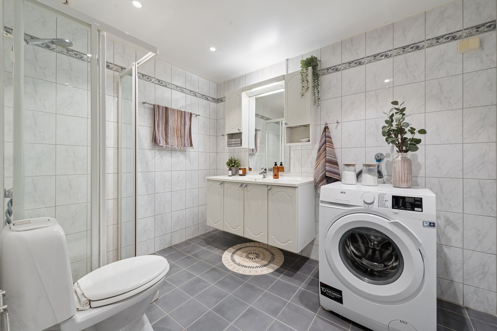 Badet er fra byggeår og har flislagte vegger og gulv. Det er varmekabel og mekanisk avtrekk. Galleribilde