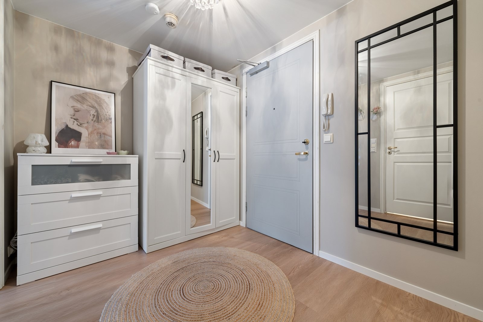 Man ønskes velkommen inn i en romslig entré. Her er det plass til garderobeskap og kommode. Porttelefon. Galleribilde