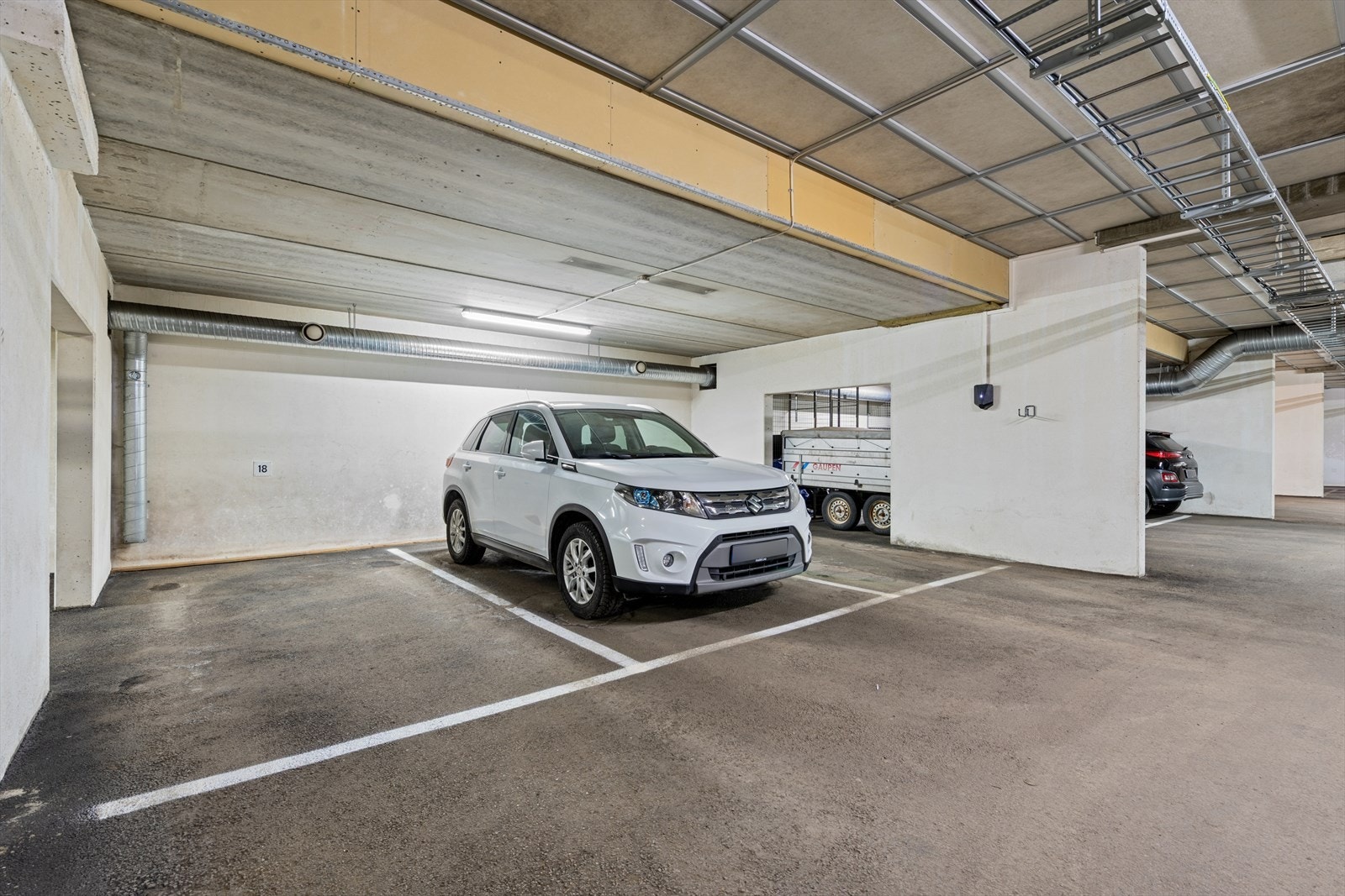 Det er heis ned til garasjeanlegget. Parkering i felles garasjeanlegg sikrer enkel tilgang til bilen. Plass nr. 18 sees til venstre i bildet. Galleribilde