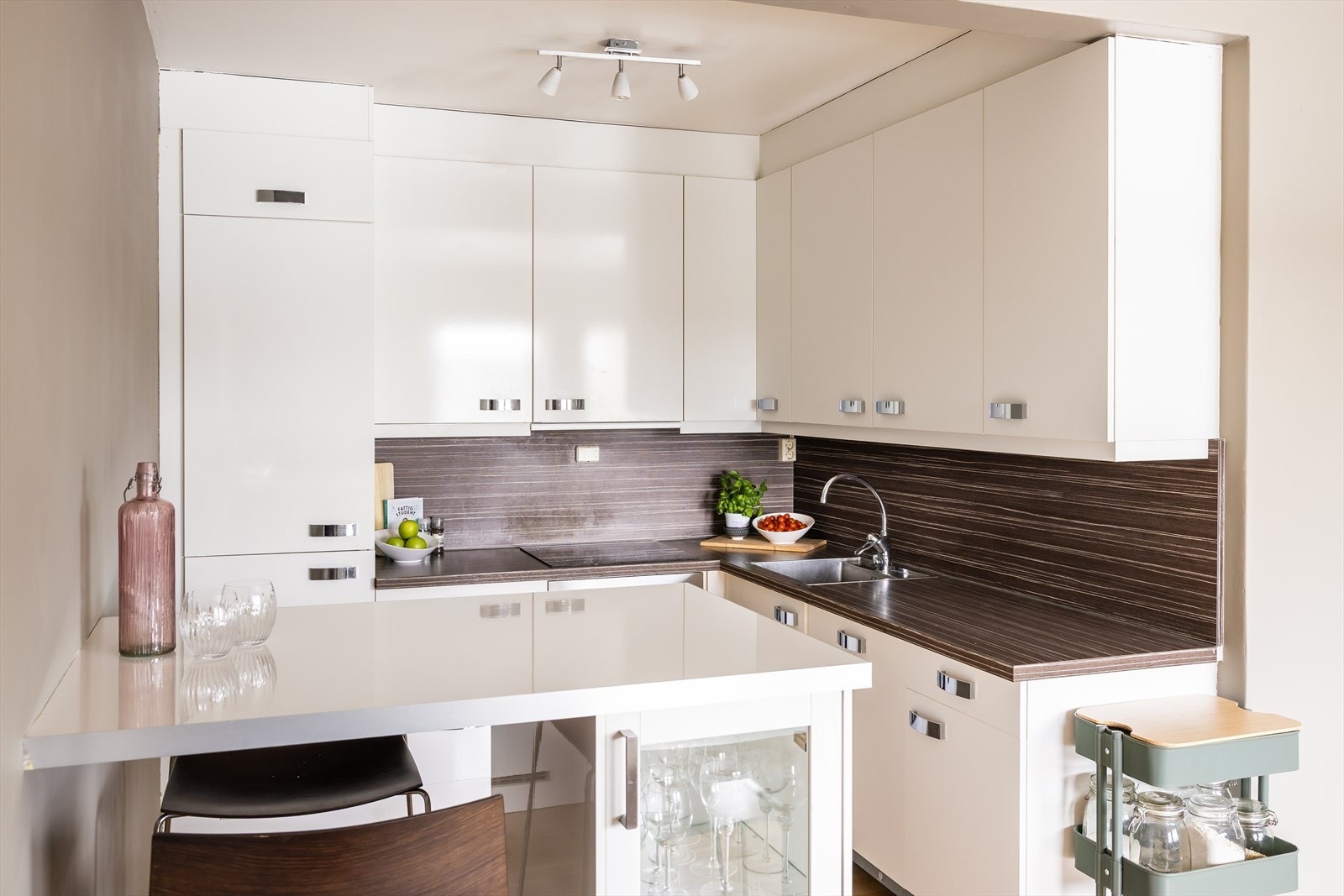 Kjøkkenet er utstyrt med integrerte hvitevarer som kombiskap, oppvaskmaskin, platetopp og stekeovn. Galleribilde