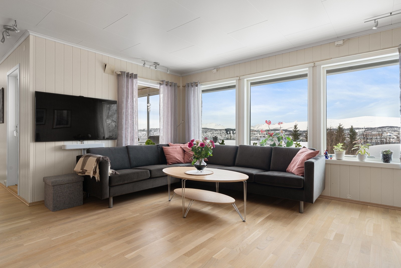 Lys og innbydende stue med malte veggoverflater og parkettgulv fra 2021. Galleribilde