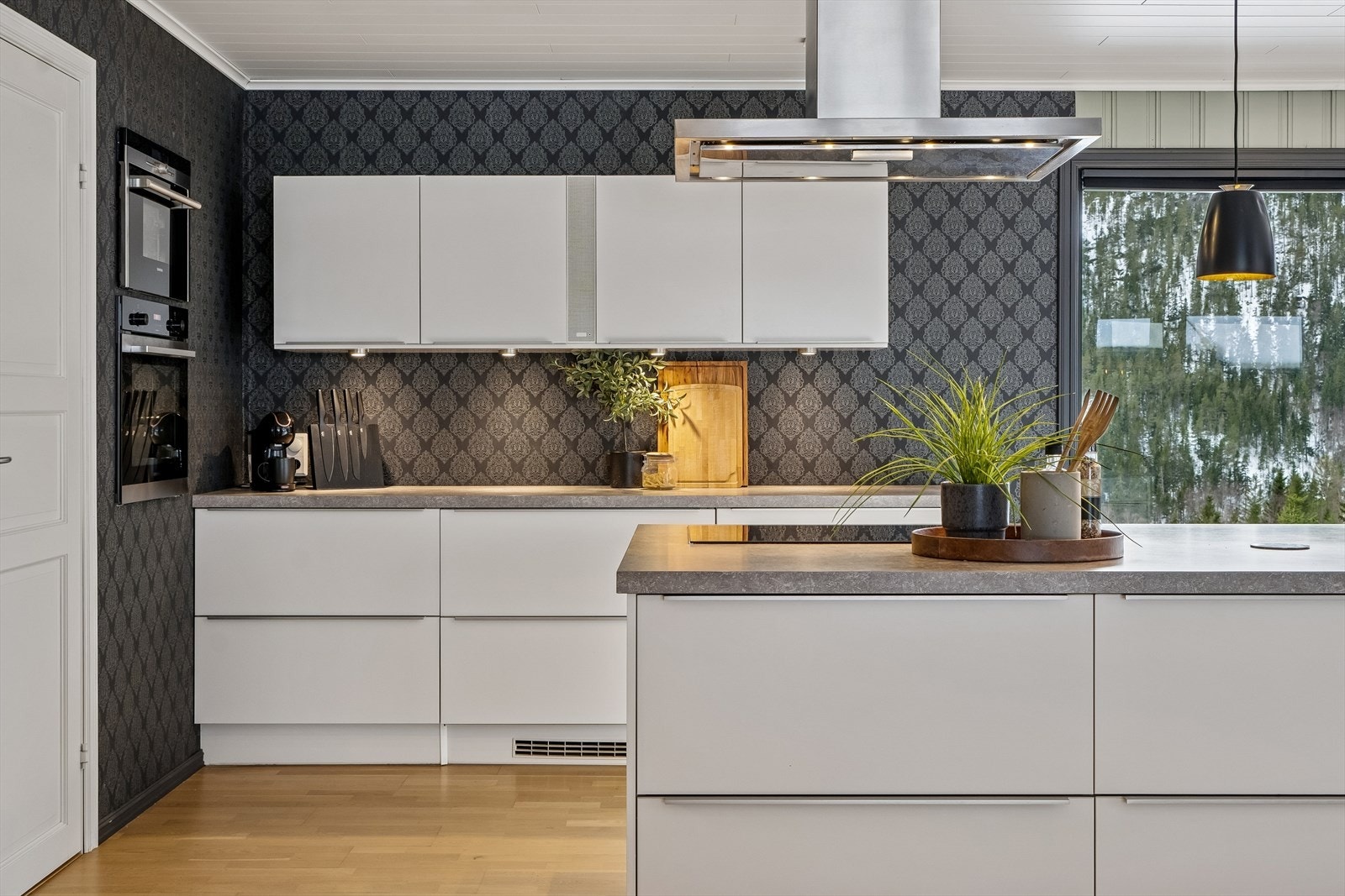 Integrerte hvitevarer med stekeovn, dampovn og oppvaskmaskin. Stor kjøkkenøy med platetopp og vaskekum. Fritthengende ventilator i stål. Galleribilde