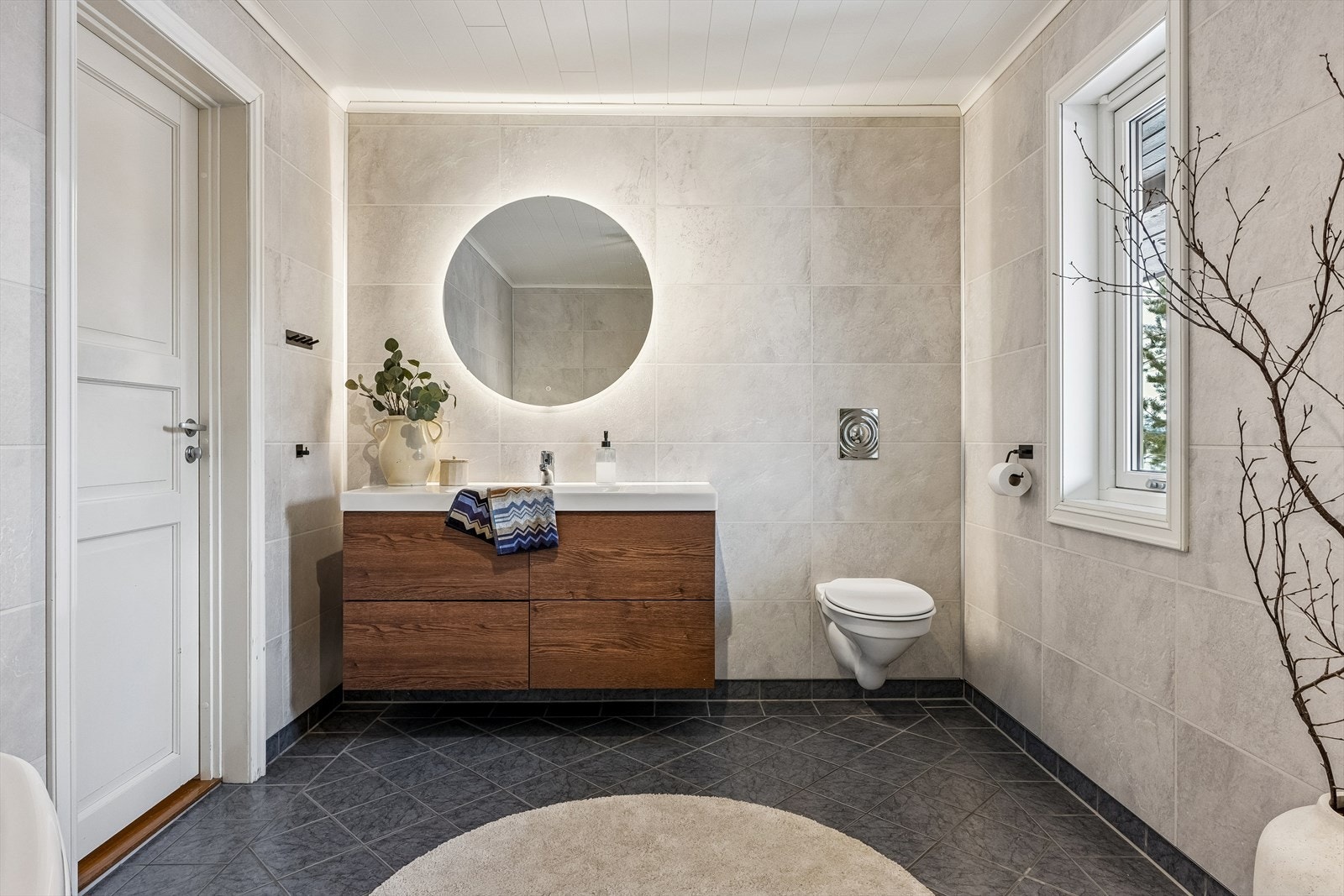 Stilrent bad fra 2006 med flislagt gulv og våtromsplater på vegger. Veggplatene ble skiftet i 2022. Galleribilde