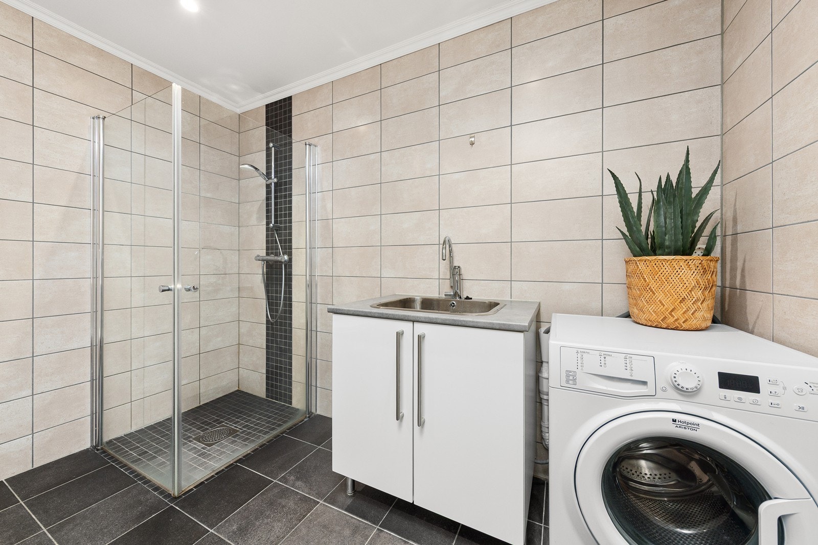 I tillegg er det en skapinnredning med vaskekum og opplegg for vaskemaskin, noe som gjør badet både funksjonelt og praktisk. Galleribilde