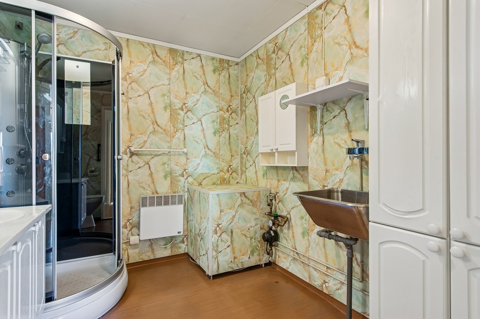 Her er det opplegg for vaskemaskin, en praktisk utslagsvask og boligens varmtvannsbereder. Galleribilde