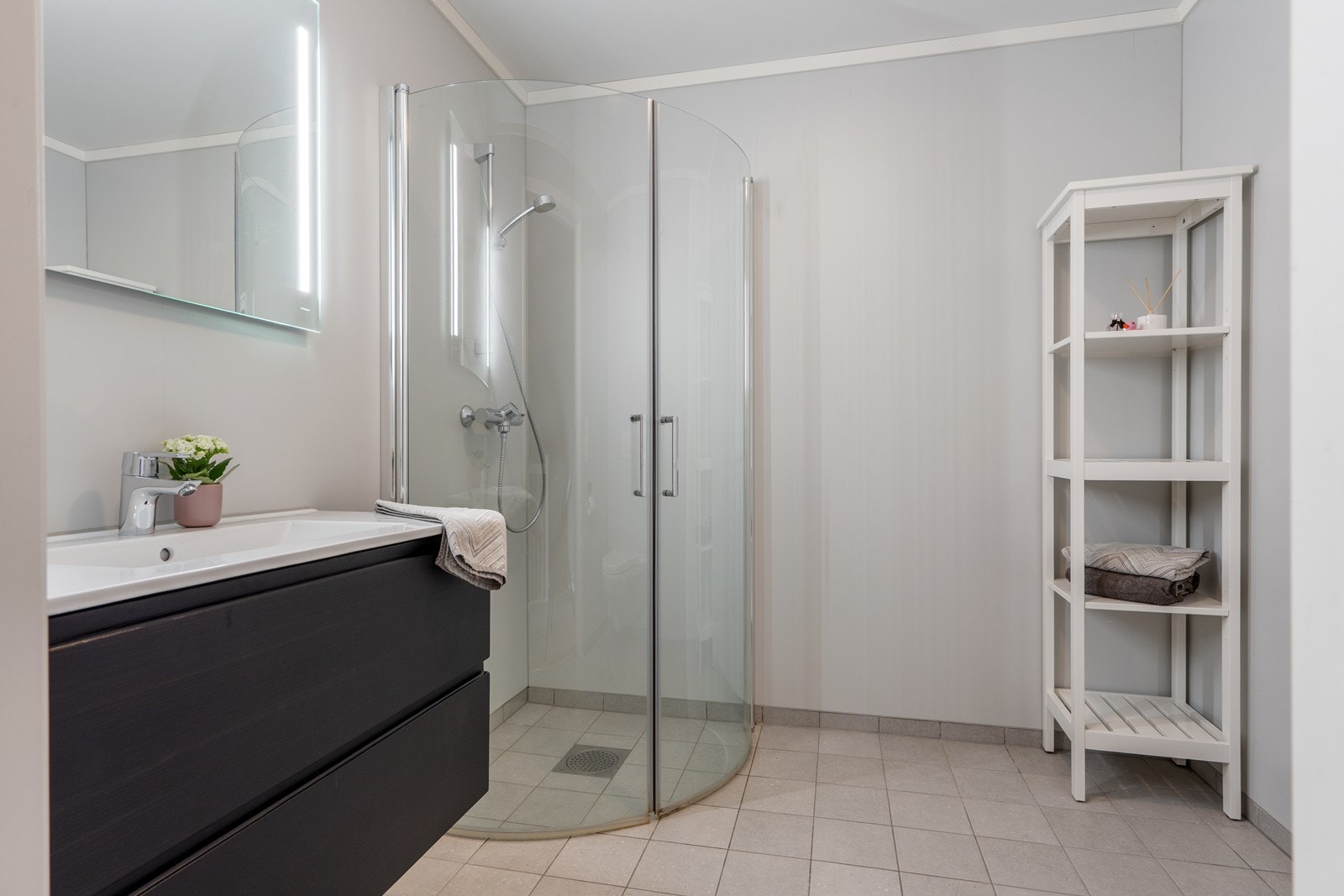 Badet i 2. etasje er delikat og innredet med vegghengt wc, dusjsone, baderomsinnredning med skuffer og nedfelt servant samt speil med integrert belysning Galleribilde