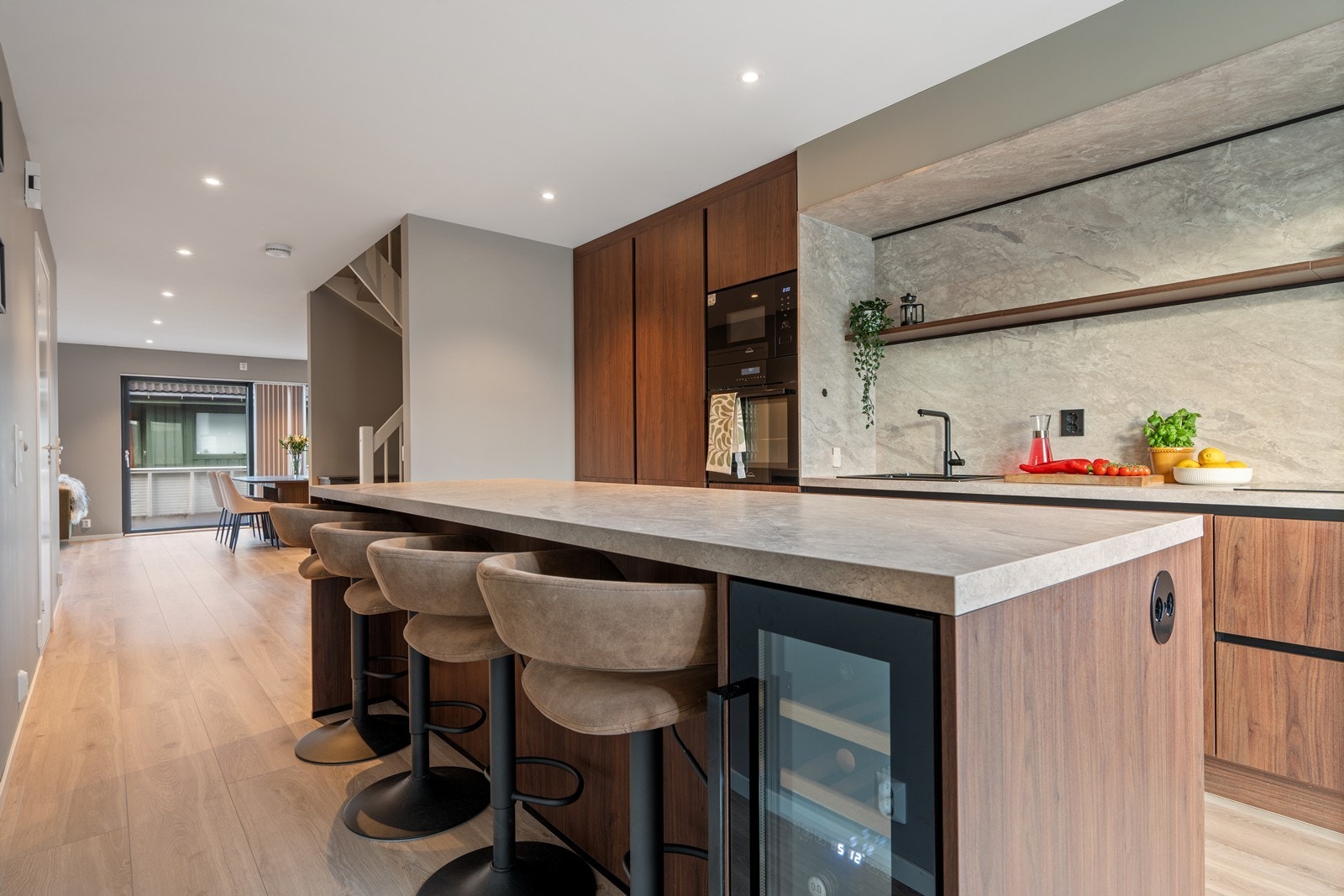 Vinskap i kjøkkenøy samt praktisk ladepunkt integrert i benkeplaten Galleribilde