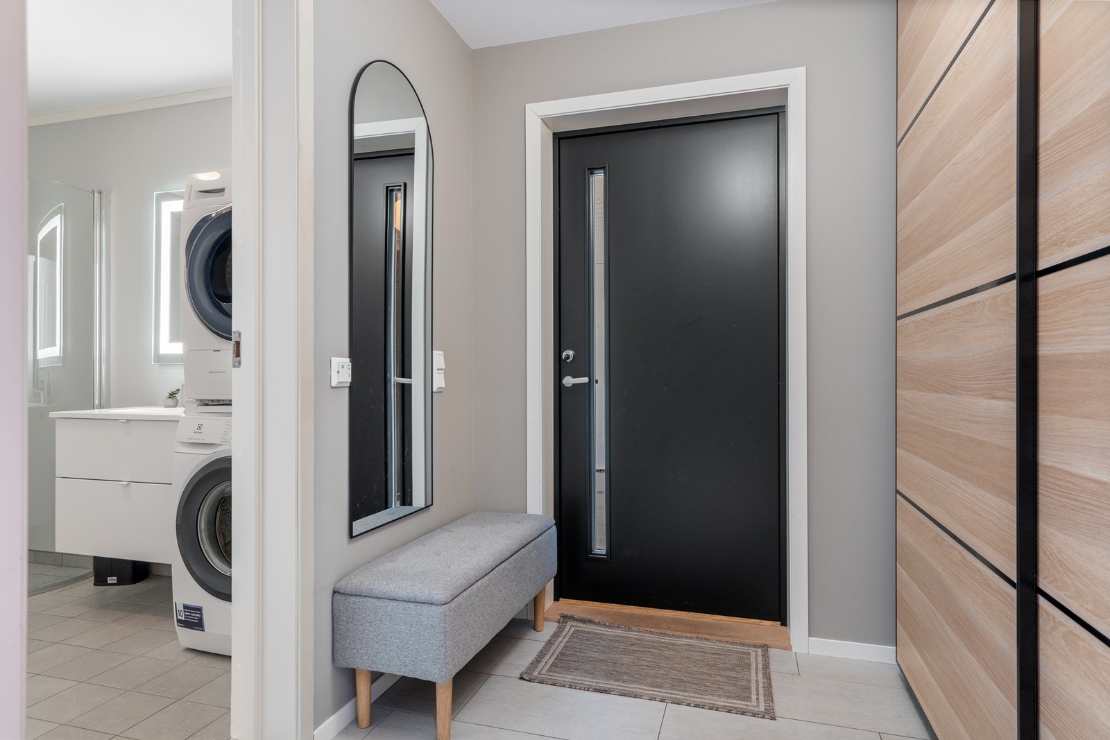 Velkommen inn! entré med flislagt gulv og praktisk skyvedørsgarderobe for yttertøy og sko. Fra gangen er det direkte adkomst til et delikat bad Galleribilde