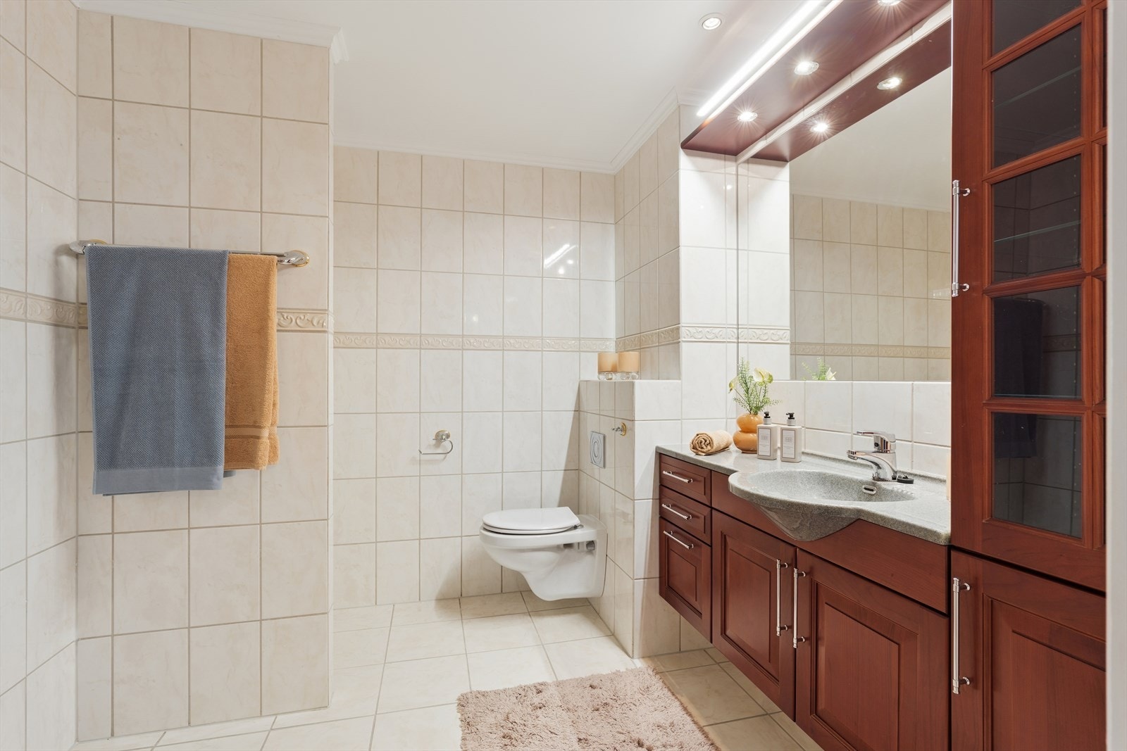 Badet har vegghengt toalett, servantinnredning og elektriske varmekabler i gulvet for ekstra komfort. Galleribilde