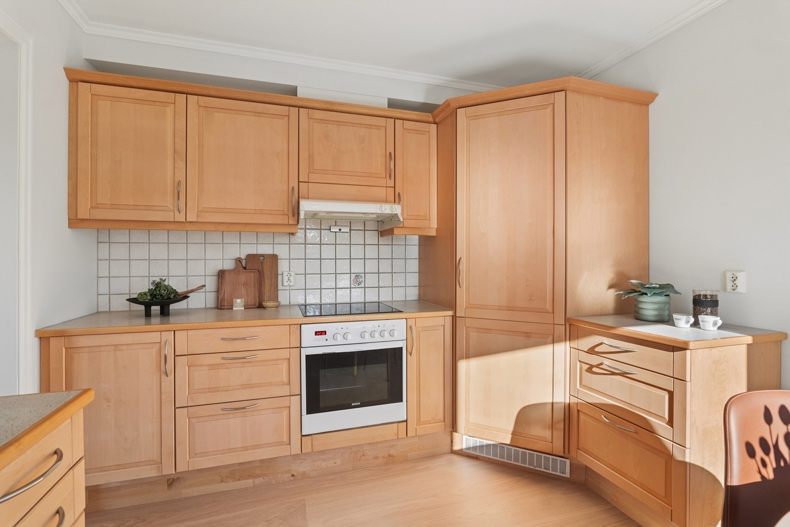 Kjøkkenet har en funksjonell innredning i bjørk med integrerte hvitevarer og laminat benkeplate. Galleribilde