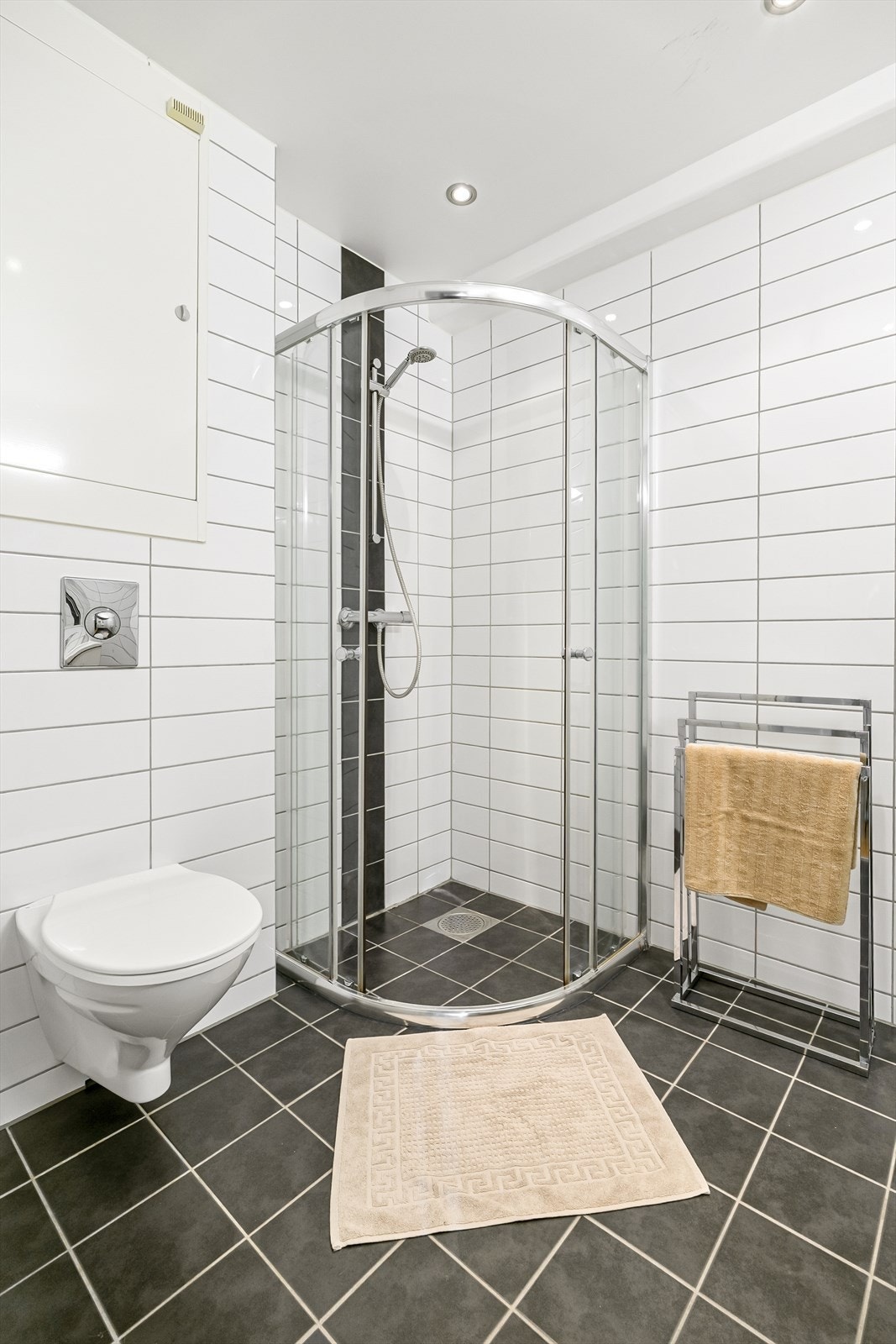 Innredet med vegghengt toalett, servant i baderomsinnredning og dusjhjørne. Galleribilde