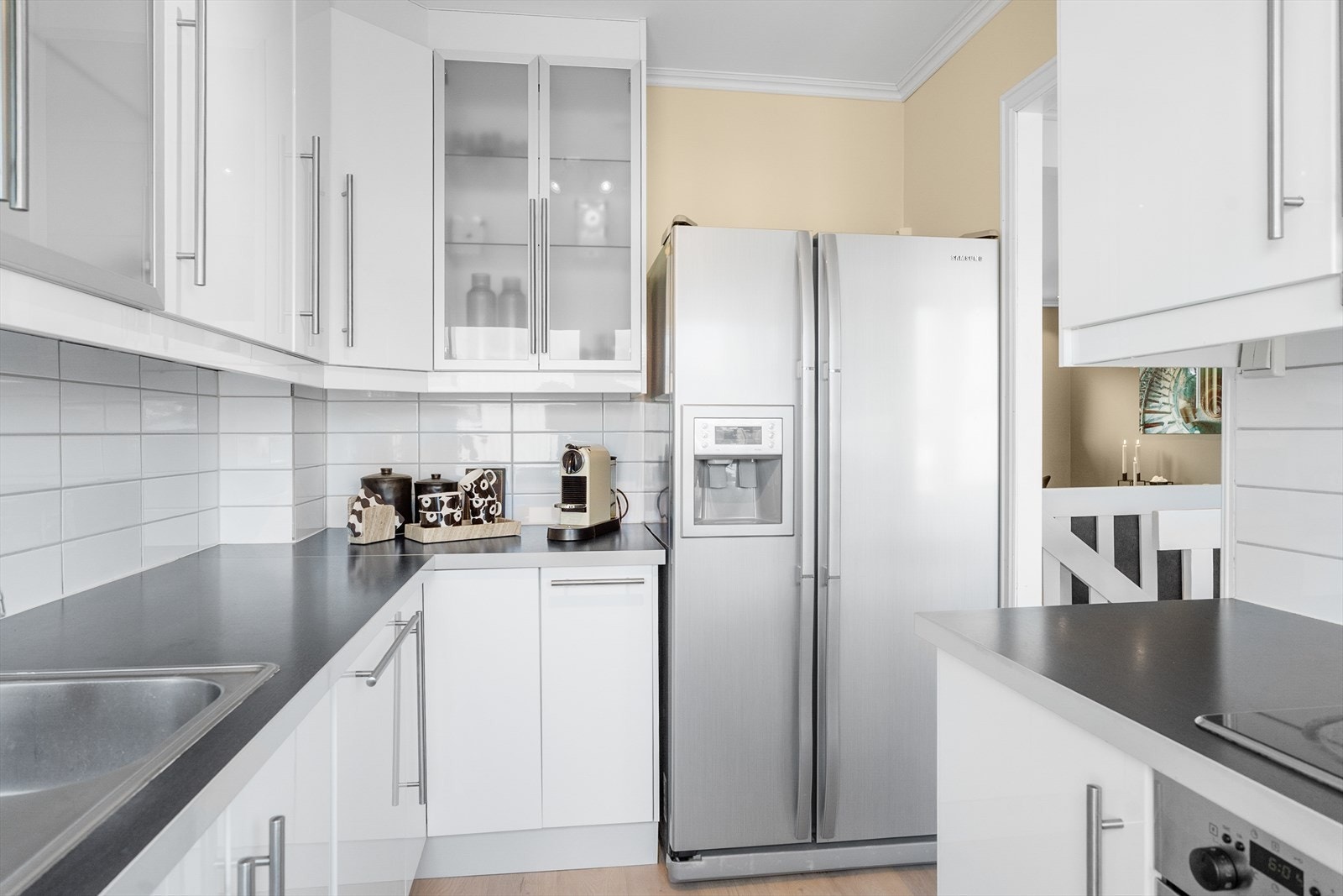 Kjøkkenet har innredning med slette fronter og laminat benkeplate - det er også fliser mellom over- og underskap for enklere renhold Galleribilde