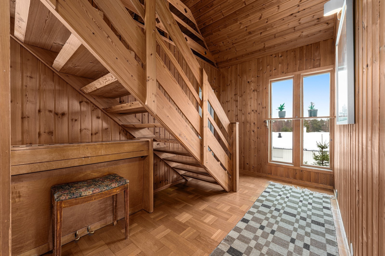 En tretrapp med åpne opptrinn leder opp til boligens andre etasje. Galleribilde