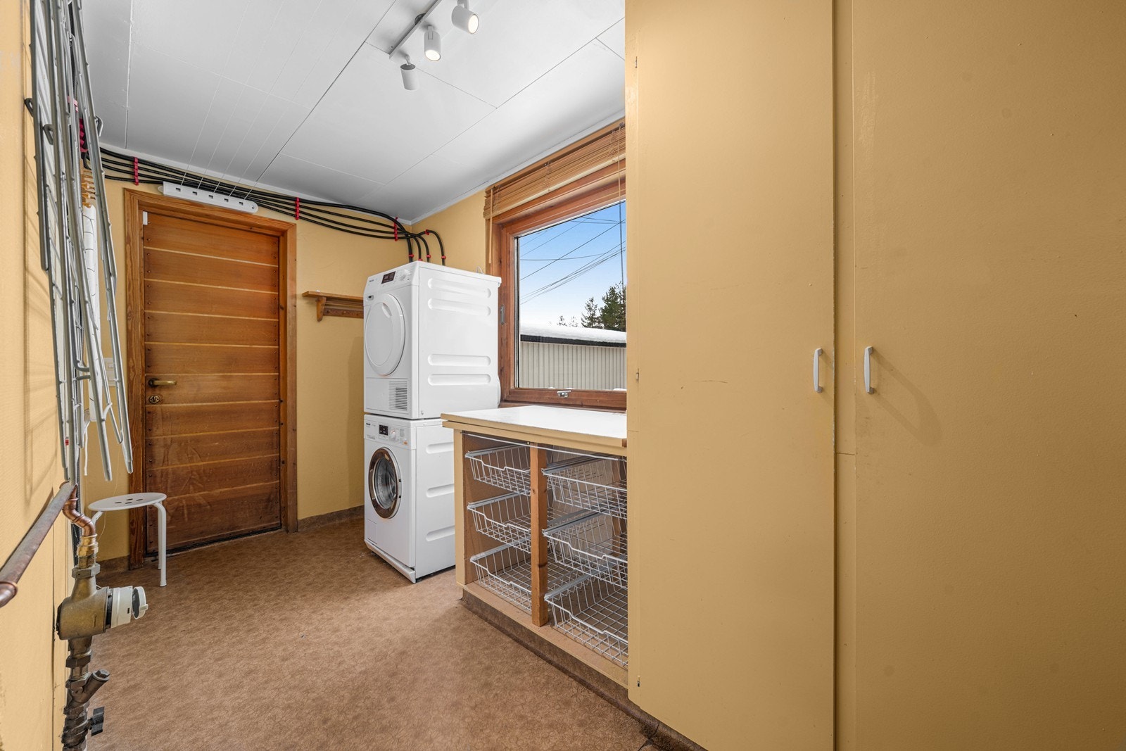 Praktisk vaskerom med opplegg for vaskemaskin. Galleribilde