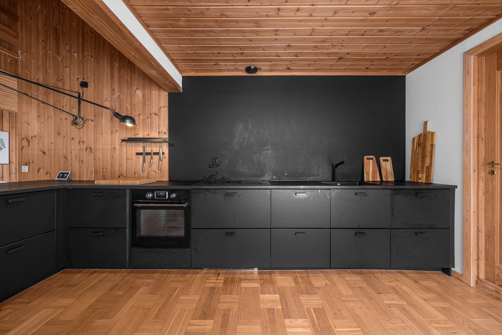 Moderne kjøkkeninnredning med stilrene, sorte fronter og integrerte hvitevarer. Galleribilde