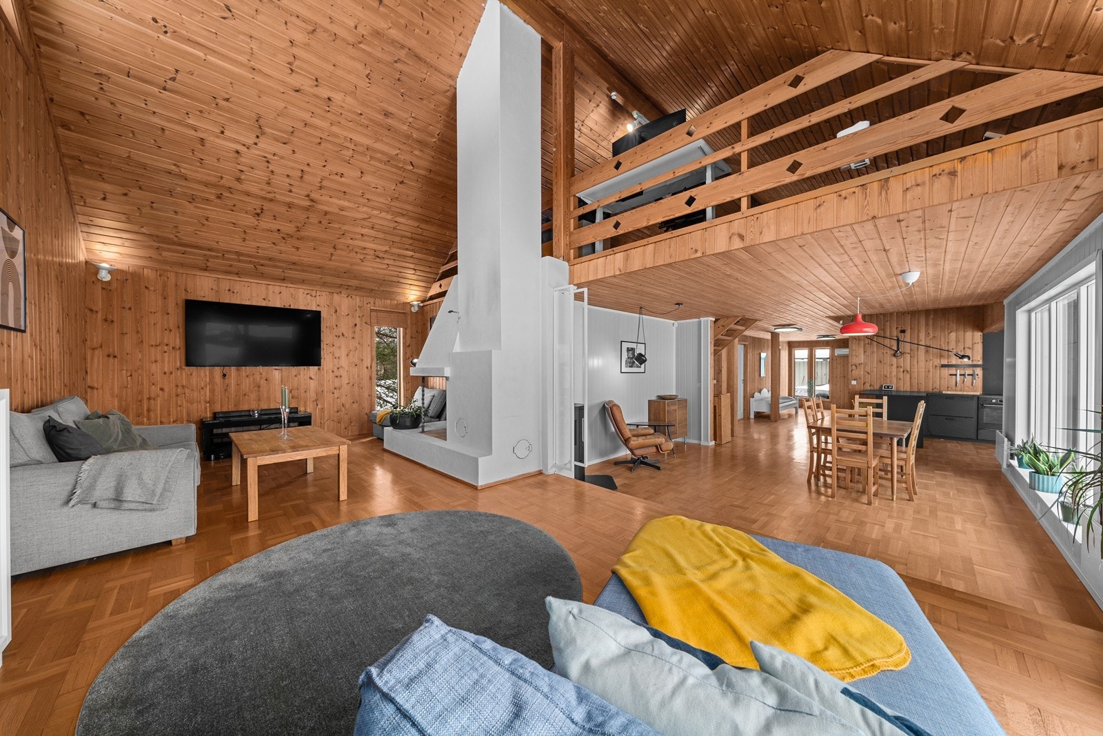 Den åpne himlingen opp til den innredede loftstuen gir en luftig romfølelse i stuen. Galleribilde