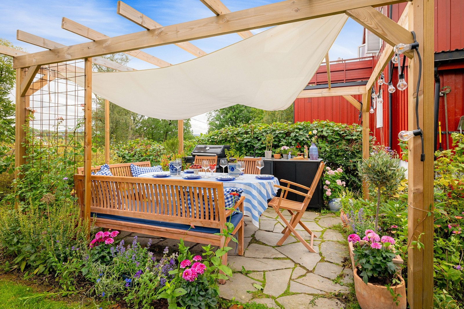 Hagen fremstår velstelt med grønn gressplen, staudebed, hekk og et rikt utvalg av frukt- og bærvekster. Galleribilde