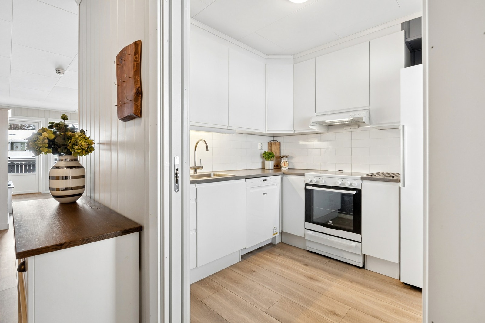 Leiligheten har et stilrent kjøkken med hvite, glatte fronter. Galleribilde