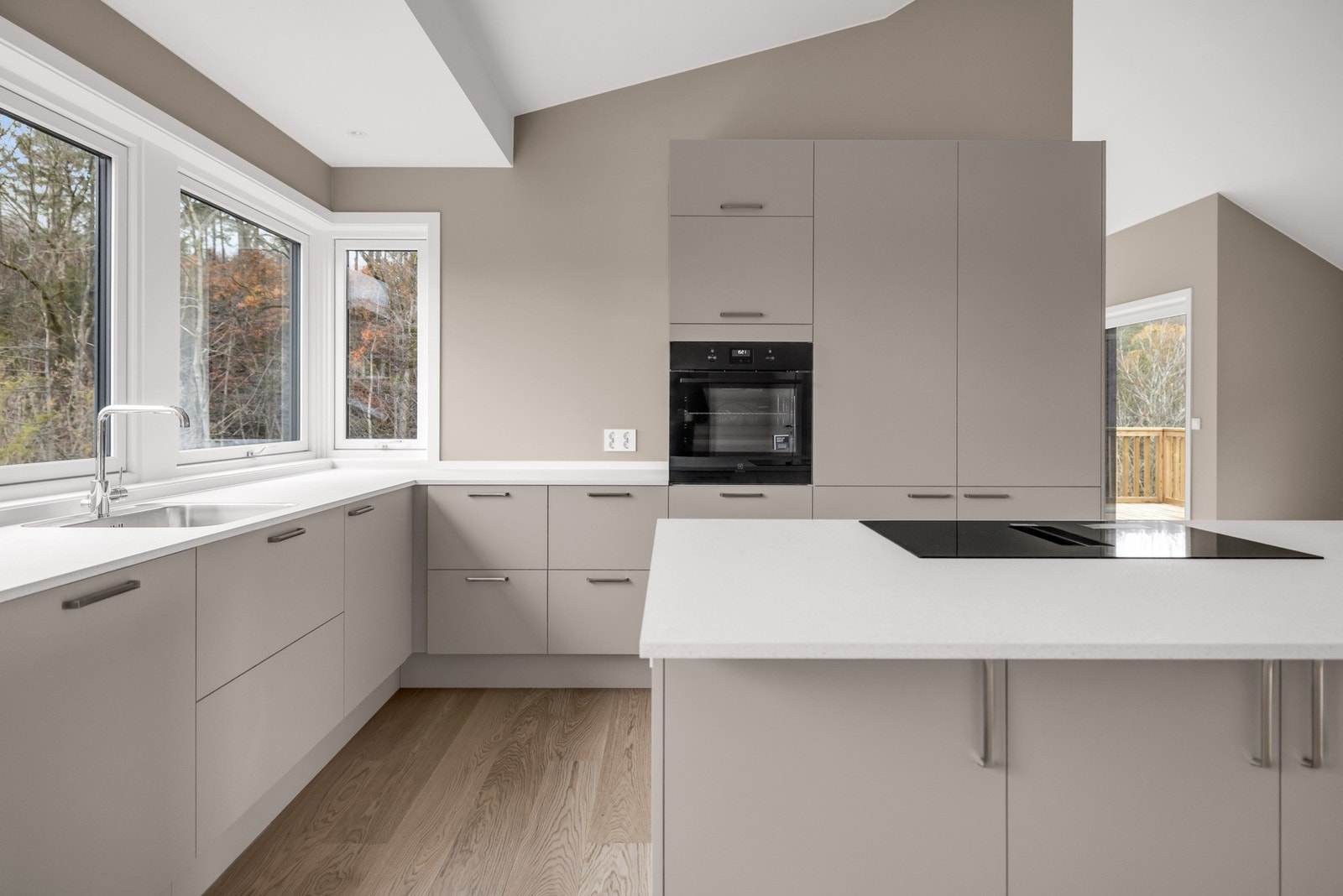 Stor kjøkkenøy med plass til barstoler på den ene siden. Galleribilde