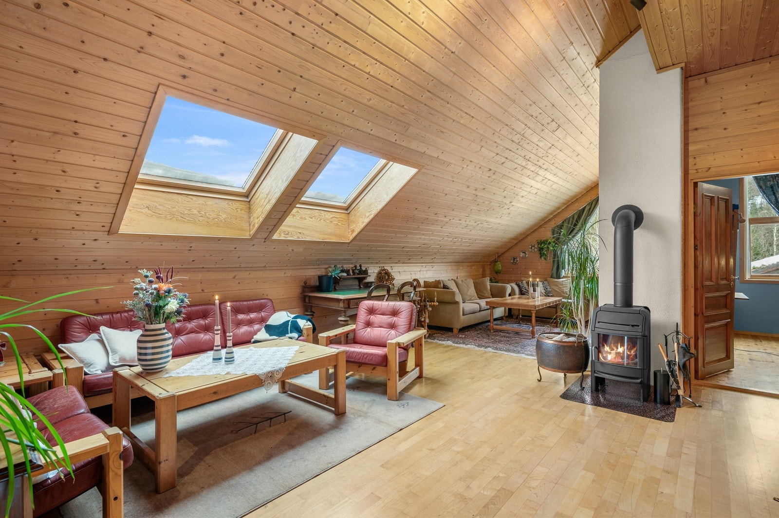 Godt gjennomlys på loftstua fra takvindu og vindu på gavlvegg. Vedfyring også her. Galleribilde