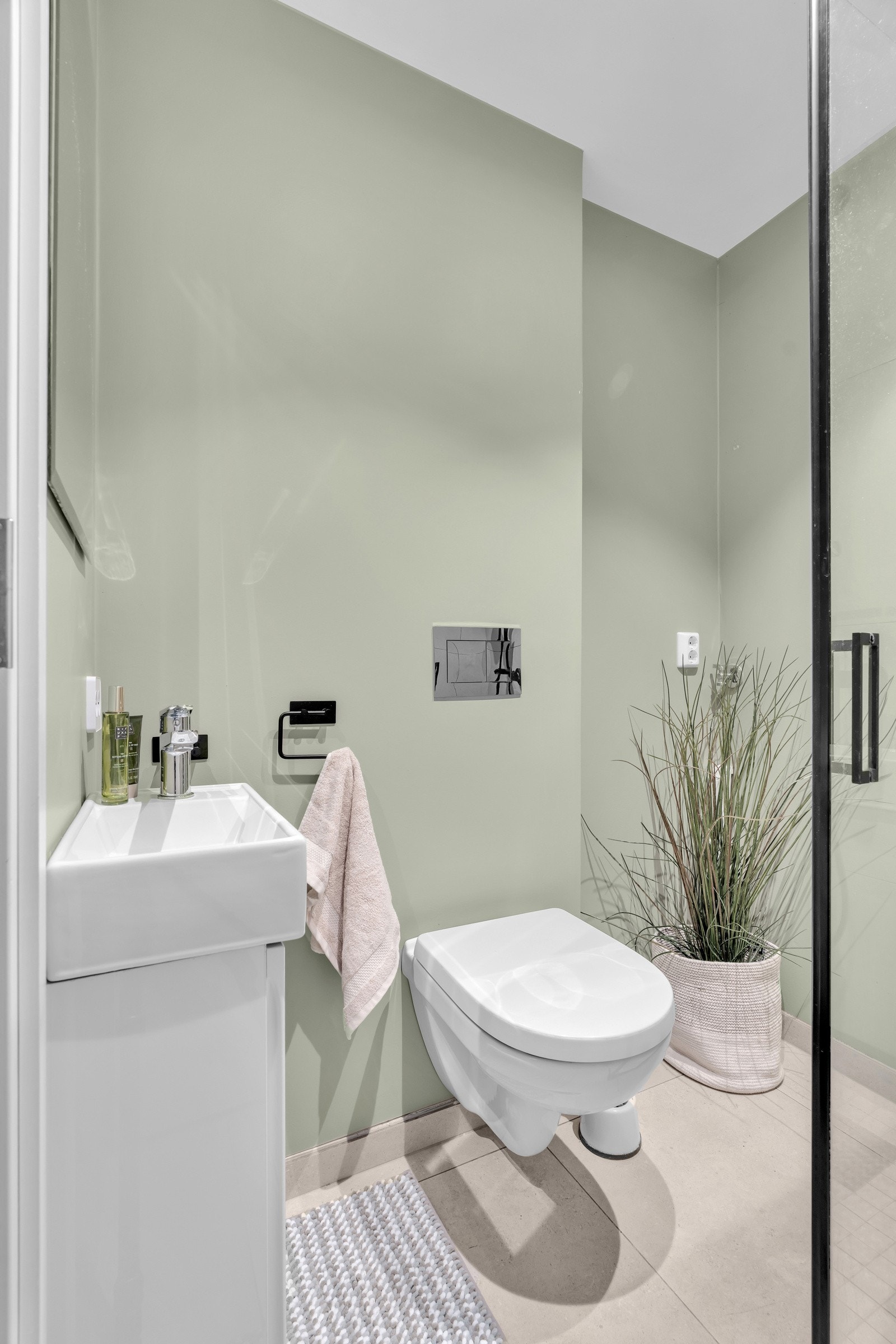 Ellers er veggene på badet malt i en behagelig og dus grønntone Galleribilde