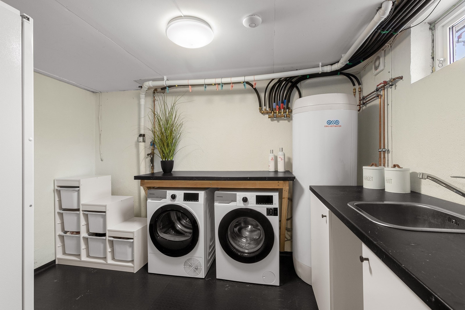 Praktisk separat vaskerom i kjelleretasje. Her er det opplegg for vaskemaskin og tørketrommel Galleribilde