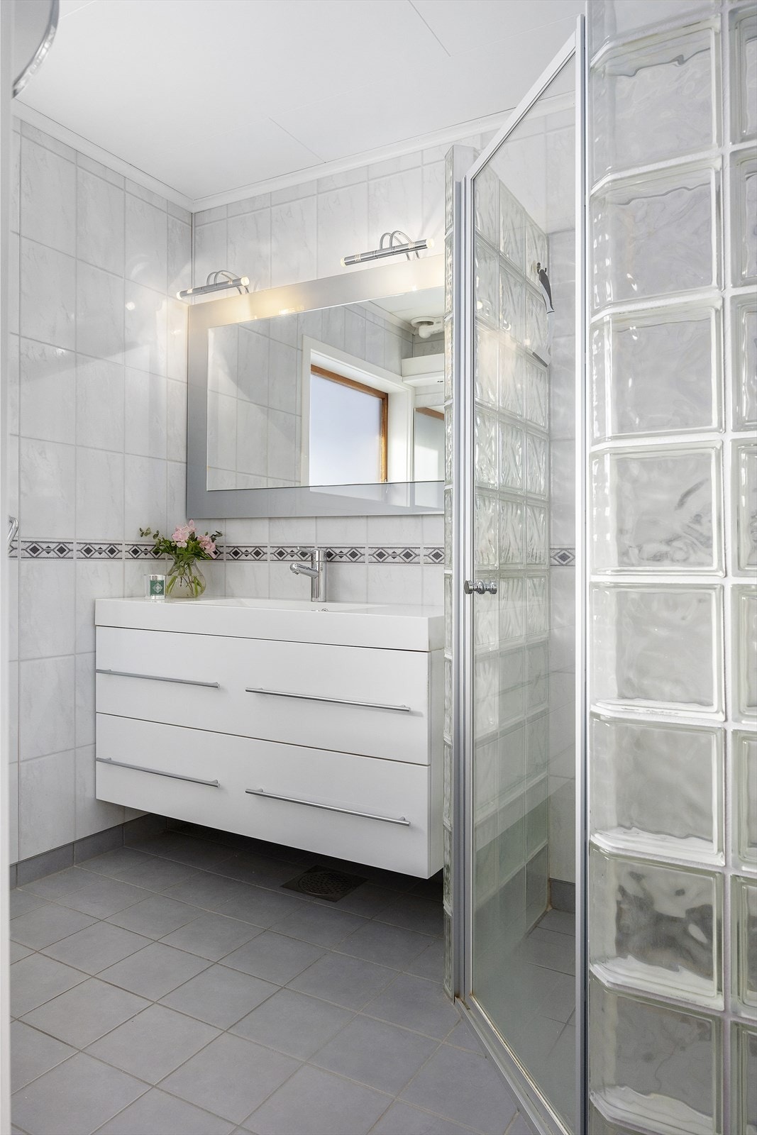 Hovedbadet i boligen er fliselagt og gir et inntrykk av kvalitet og moderne komfort Galleribilde