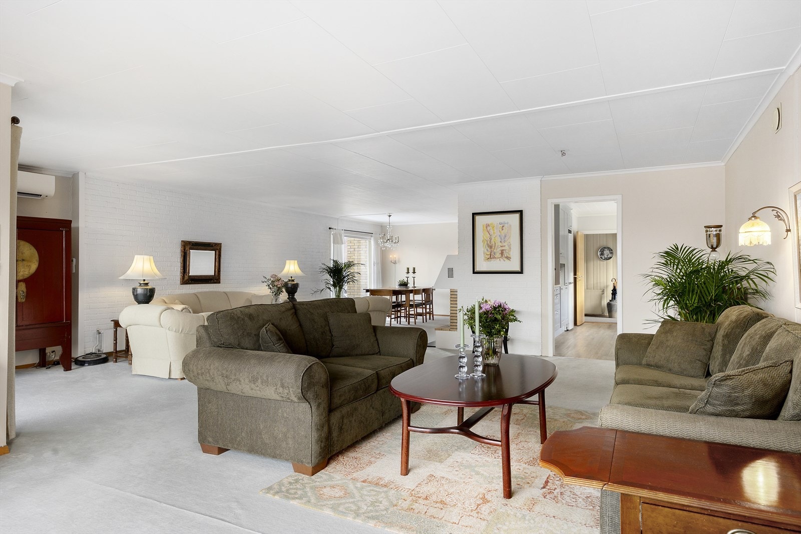 Store vindusflater slipper inn rikelig med dagslys og skaper en lys og luftig atmosfære. Her er det plass til både sofagrupper og spisebord, og du har direkte utgang til en flott terrasse og uteområde - perfekt for sommerdager og sosiale sammenkomster. Galleribilde