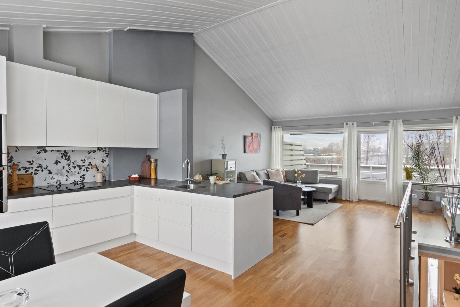 Innredningen har hvite, glatte fronter og kokegrå laminatbenkeplate med nedfelt oppvaskkum i stål. Galleribilde