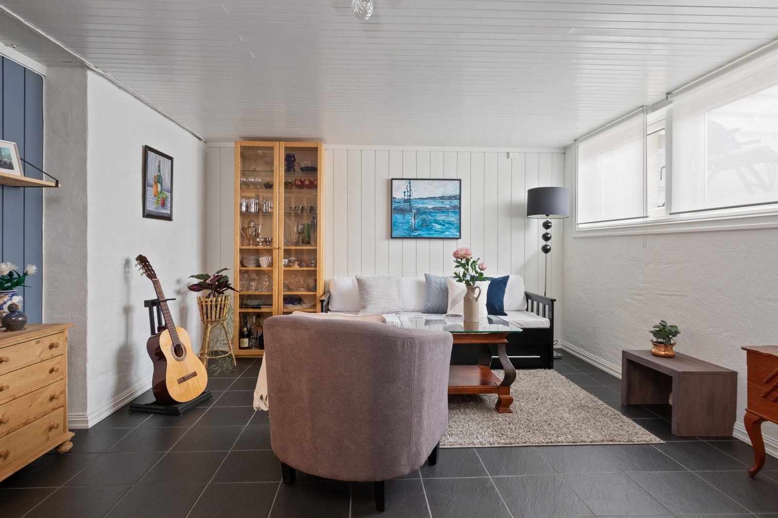 Veggene er malt i lyse toner med innslag av blått, og på gulvet er det koksgrå fliser. To store vinduer slipper inn godt med naturlig lys. Galleribilde