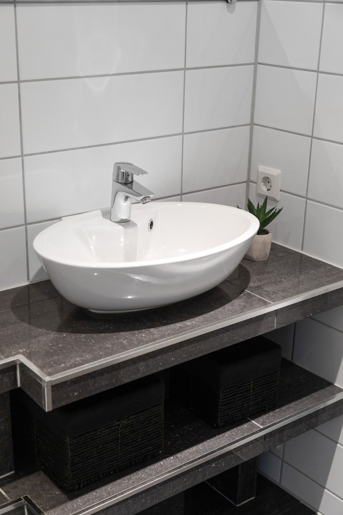 Innredningen består av toppmontert servant på helfliset benk med bredt speil over. Galleribilde