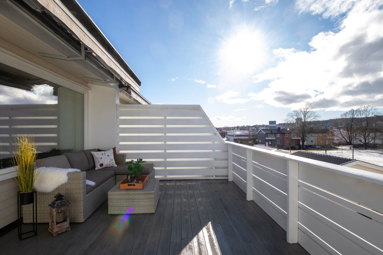 Balkongen er utstyrt med elektrisk terrassemarkise som gir effektiv solskjerming på varme dager, og levegger på hver side skaper lune og skjermede forhold. Galleribilde