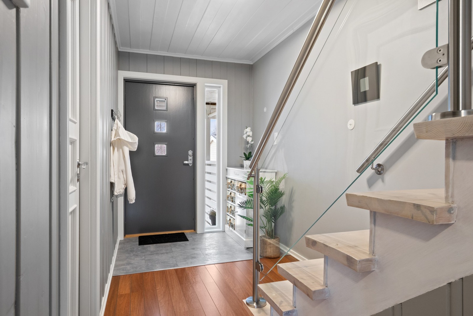 Hyggelig entré med gråmalte vegger og lysegrå fliser på gulvet. Galleribilde