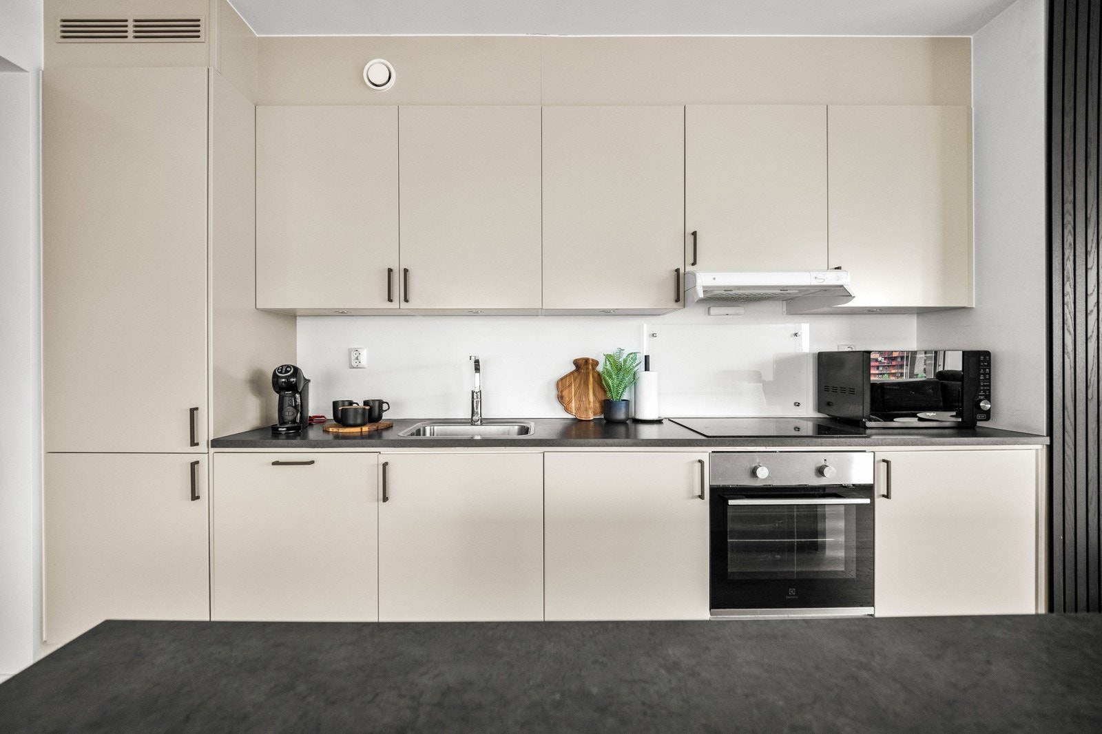 Stilrent kjøkken fra Drømmekjøkken med integrerte hvitevarer som kjøl/fryseskap, oppvaskmaskin, platetopp og stekeovn. Galleribilde