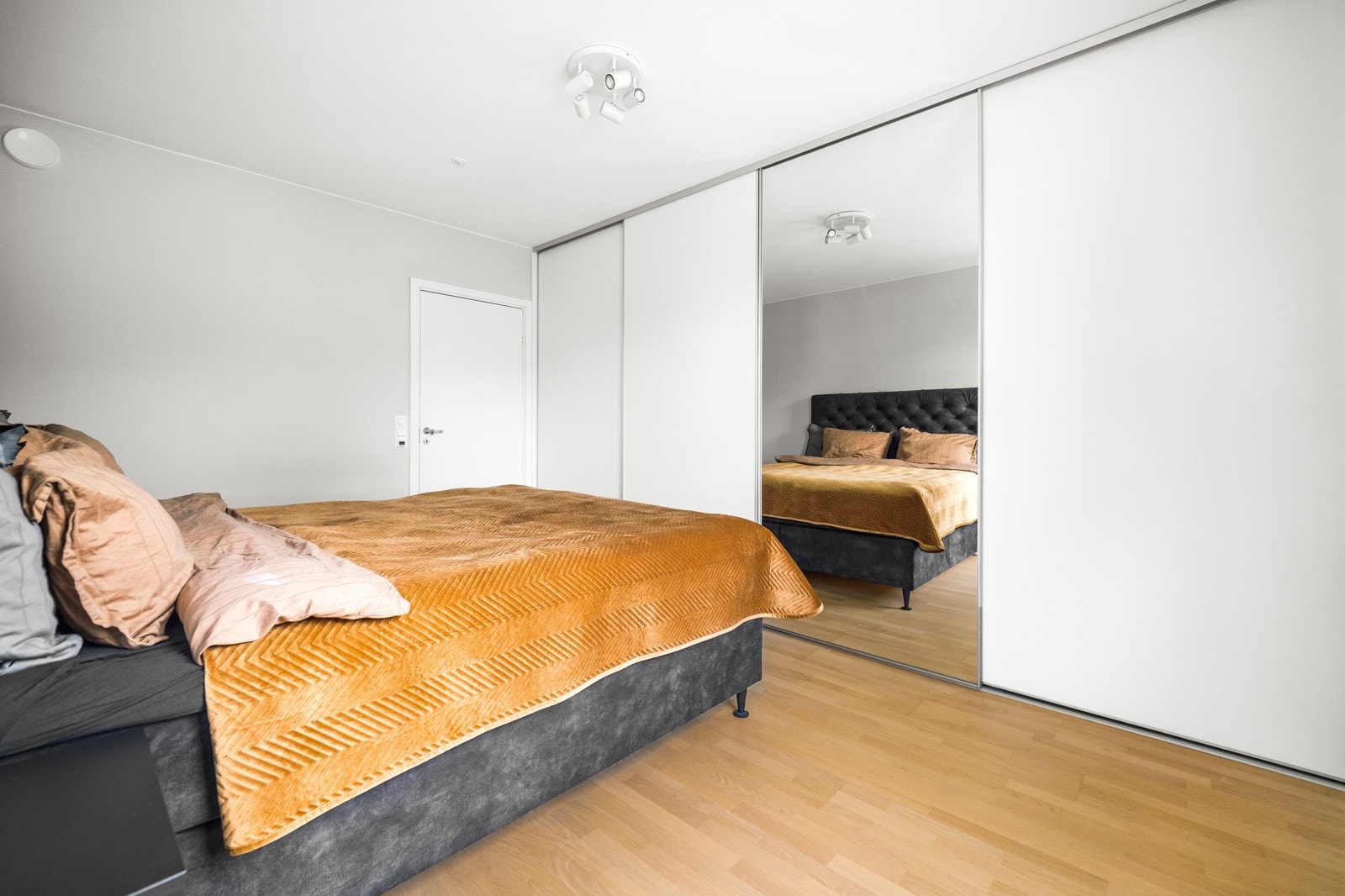 Stor skyvedørsgarderobe med smarte oppbevaringsløsninger og speildør som bidrar til den luftige romfølelsen. Galleribilde