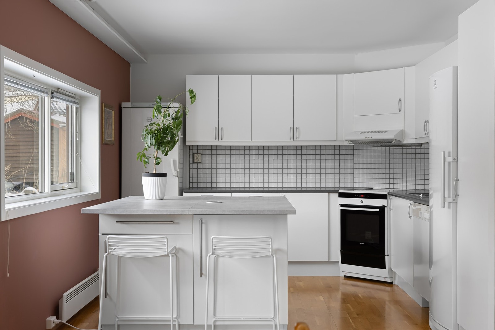 Pent og tidløst kjøkken som har en brukervennlig utforming og kjøkkenøy for lagring og bespisning. Galleribilde